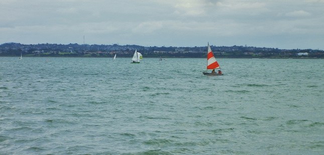 Love the red and white sail on the small yacht.